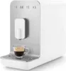 A white SMEG coffee machine with a cup of coffee on the drip tray. Voir les images du produit