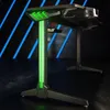 A black gaming desk with green LED lighting, shown from a low angle in a dark room with blue diagonal lights in the background. Náhľad obrázku produktu