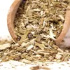 A close-up of dried yerba mate leaves and stems spilling out of a wooden scoop. Podgląd zdjęcia produktu