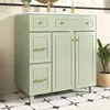 A light green bathroom vanity with gold hardware sits on a black and white tiled floor. Anteprima dell’immagine prodotto