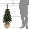 A small artificial Christmas tree is shown next to a silhouette of a person, with height markers indicating measurements in centimeters. Náhled obrázku produktu
