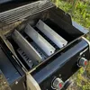 A close-up view of the inside of a grill, showing three metal heat shields. Podgląd zdjęcia produktu