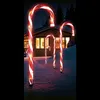 Christmas candy cane lights in the snow in front of a house at night. Produktbild-Vorschau