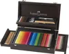 An open wooden case filled with art supplies, including colored pencils, charcoal, and other drawing tools. Anteprima dell’immagine prodotto