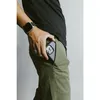 A person is putting a phone into their pocket, showing a watch on their wrist. Anteprima dell’immagine prodotto