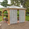 A gazebo with curtains on a paved patio in a garden setting. Produktbild-Vorschau