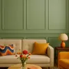 A living room scene with a sofa, pillows, flowers, and a lamp. Produktbild-Vorschau