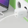 A white Belkin dual USB-C PD charger is plugged into a wall socket, with a white USB-C cable connecting it to a laptop. Náhľad obrázku produktu