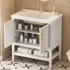 A white bathroom vanity with a sink and faucet, open doors revealing shelves with toiletries and towels. Voir les images du produit