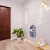 An entryway or hallway with a wooden door, a plant, a mirror, and a hanging organizer with slippers. Náhľad obrázku produktu