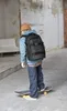A person is skateboarding while wearing a backpack. Produktbild-Vorschau