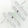 Two white door handles with keyholes are arranged diagonally on a light background. Produktbild-Vorschau