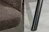A split image showing a close-up of a brown fabric chair and a black metal chair leg. Produktbild-Vorschau