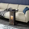 A side table with a book and a cup of coffee on it, placed next to a sofa. Produktbild-Vorschau