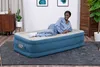 A woman is lying on an inflatable mattress in a room. Produktbild-Vorschau