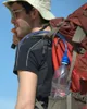 A person hiking with a backpack and a water bottle attached. Podgląd zdjęcia produktu