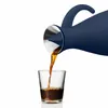 A navy blue carafe pouring coffee into a clear glass. Voir les images du produit