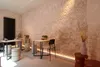 A room with a brick wall, tables, and stools, illuminated by LED strip lighting. Produktbild-Vorschau