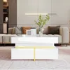 A modern living room scene featuring a white coffee table with gold accents, placed in front of a sofa. Produktbild-Vorschau