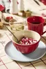 A festive table setting with a bowl of candies, a mug of coffee, and a glass of liquid. Produktbild-Vorschau