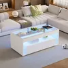 A modern living room with a white sectional sofa and a white high-gloss coffee table with LED lighting. Produktbild-Vorschau