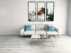 A modern living room with a white sofa, coffee tables, and abstract art on the wall. Produktbild-Vorschau