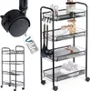 A black metal rolling cart with four shelves, shown with kitchen items and towels on it. A close-up of a caster wheel is shown in the upper left corner, with a tag that has the word "Vilde" on it. Náhled obrázku produktu