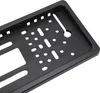 A close-up, angled view of the back of a black license plate frame with various mounting holes. Produktbild-Vorschau