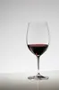 A single glass of red wine on a reflective surface against a plain background. Produktbild-Vorschau