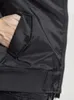 A close-up view of a person's hand in the pocket of a black bomber jacket. Produktbild-Vorschau
