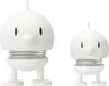 Two white spring-loaded figurines with round heads, small noses, and stick-like legs, set against a white background. Produktbild-Vorschau