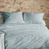 Bettwäsche mit weißen nautischen Motiven Möven und Koordinaten vor rustikaler Steinwand in gemütlichem Schlafzimmer Produktbild-Vorschau