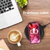 A desk scene with a laptop, a cup of coffee, and a smartphone charging wirelessly. Produktbild-Vorschau