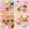 A collage of four images showing small, colorful, square plastic containers with lids, some filled with various food items like berries, nuts, candies, and marshmallows. Produktbild-Vorschau