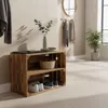A wooden crate shelf unit with shoes and a basket, placed in a hallway with coats hanging on the wall and a plant in the background. Náhled obrázku produktu