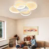 A couple sitting on the floor in a living room, with a modern ceiling lamp visible overhead. Voir les images du produit