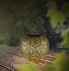 A solar lantern sits on a wooden table outdoors, with blurred greenery in the background. Produktbild-Vorschau