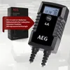 A product shot of an AEG battery charger with a box and descriptive text overlay. Produktbild-Vorschau