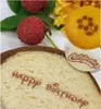 A slice of bread with text, lychees, and a small cake with a flower design. Podgląd zdjęcia produktu