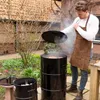 A man is grilling in a backyard with a smoker. Produktbild-Vorschau