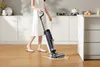 A person is using a wet and dry vacuum cleaner in a kitchen. Náhled obrázku produktu