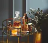 A bar cart with a decanter, glasses, shaker, and other bar accessories, with a bouquet of flowers in the background. Produktbild-Vorschau