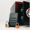 A black safe is open, with a black external hard drive and two padlocks in front of it. Produktbild-Vorschau