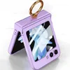 A purple flip phone case with a gold ring stand is shown on a white marble surface. Produktbild-Vorschau
