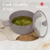 A pot of soup is shown on a wooden board, with text and logos around it. Produktbild-Vorschau