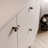 A close-up view of a dresser with textured drawer pulls. Produktbild-Vorschau