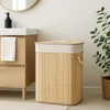 A bamboo laundry basket with a removable liner is shown in a bathroom setting next to a vanity. Podgląd zdjęcia produktu
