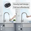 A split image showing a kitchen faucet with a pull-out spray head and a gravity ball mechanism underneath the sink. Produktbild-Vorschau