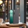 A smartphone case is displayed on a plate next to a coffee cup, with a blurred background of a cafe. Produktbild-Vorschau