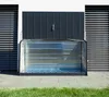 A metal storage box for bicycles is shown in front of a modern building. Náhľad obrázku produktu